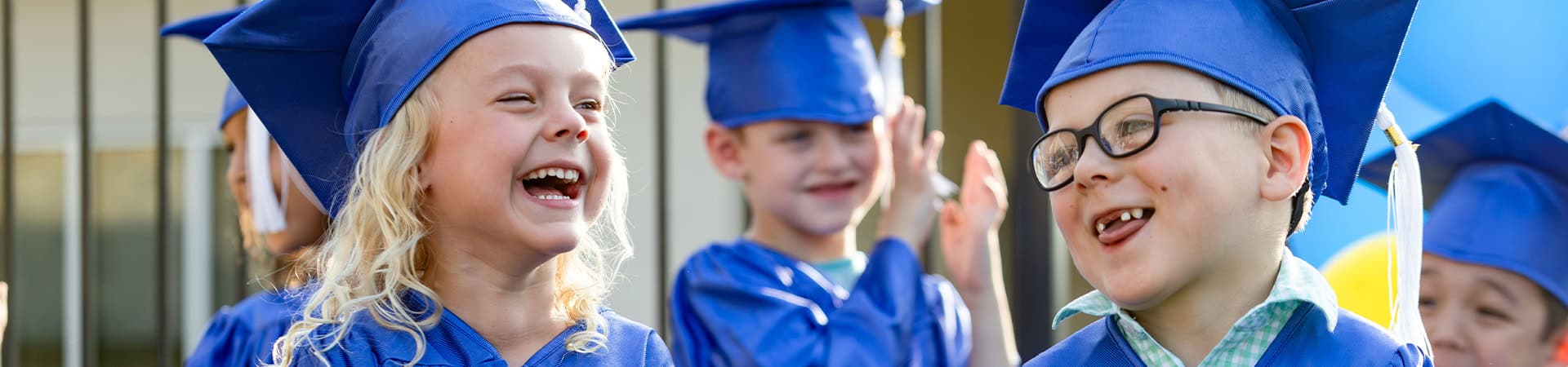 Happy Graduating Children Blue Caps Gowns
