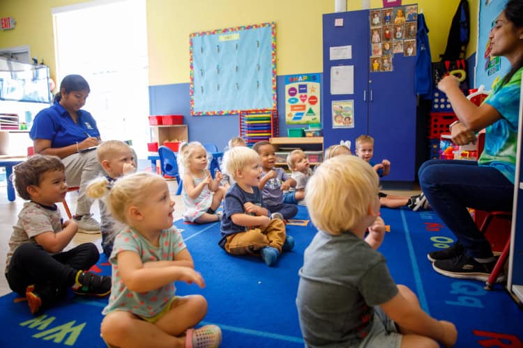 Group of preschoolers sitting on the floor for a lesson.